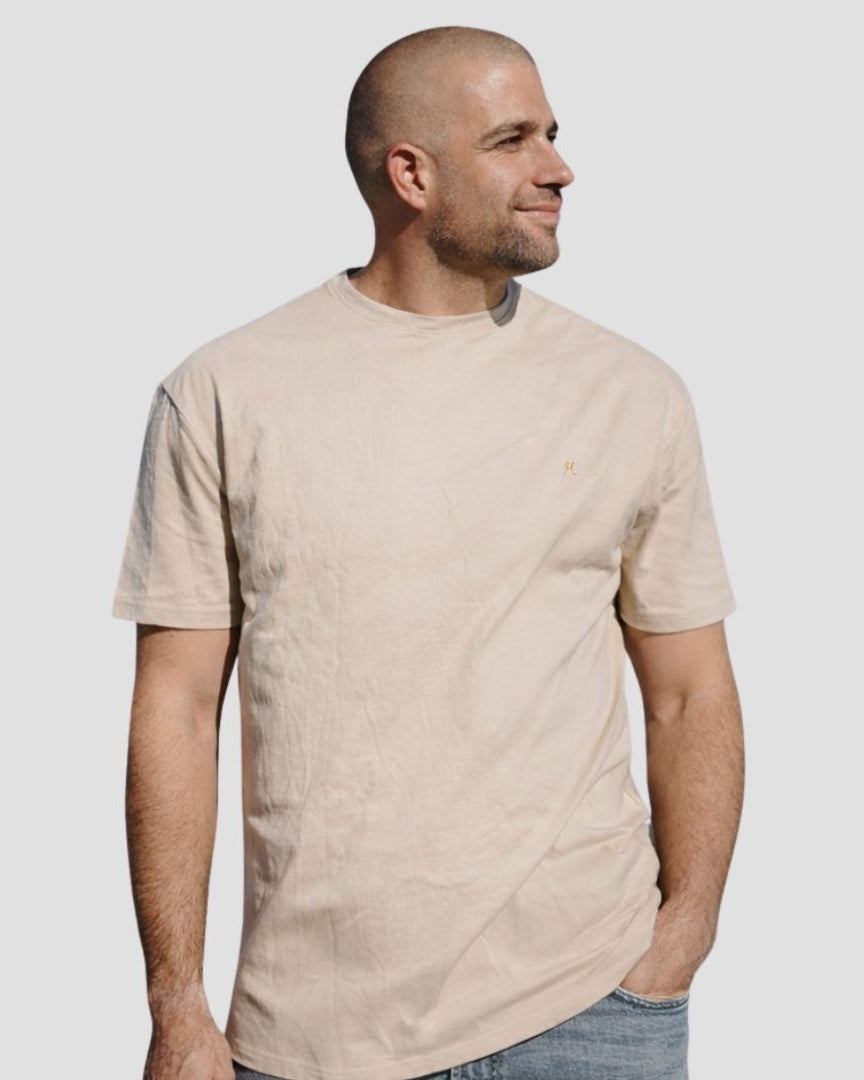 Man wearing a beige t-shirt against a plain background