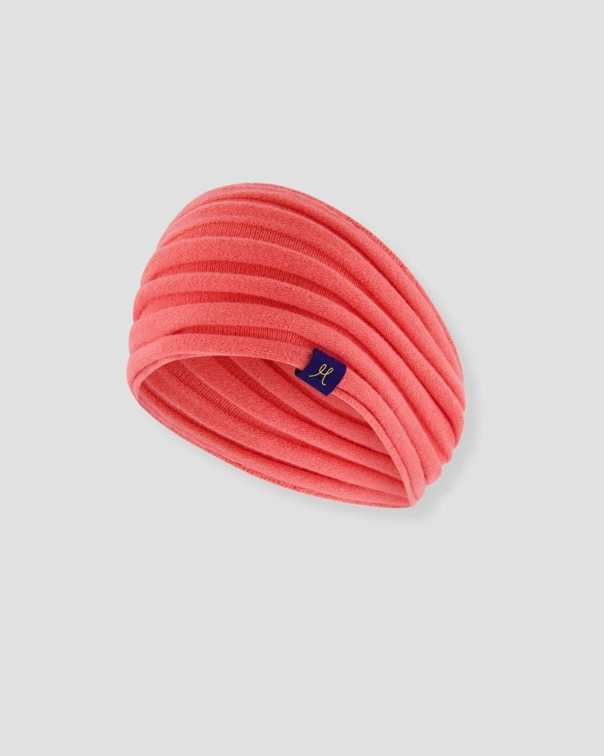 Pink headband with a brand logo on a light gray background