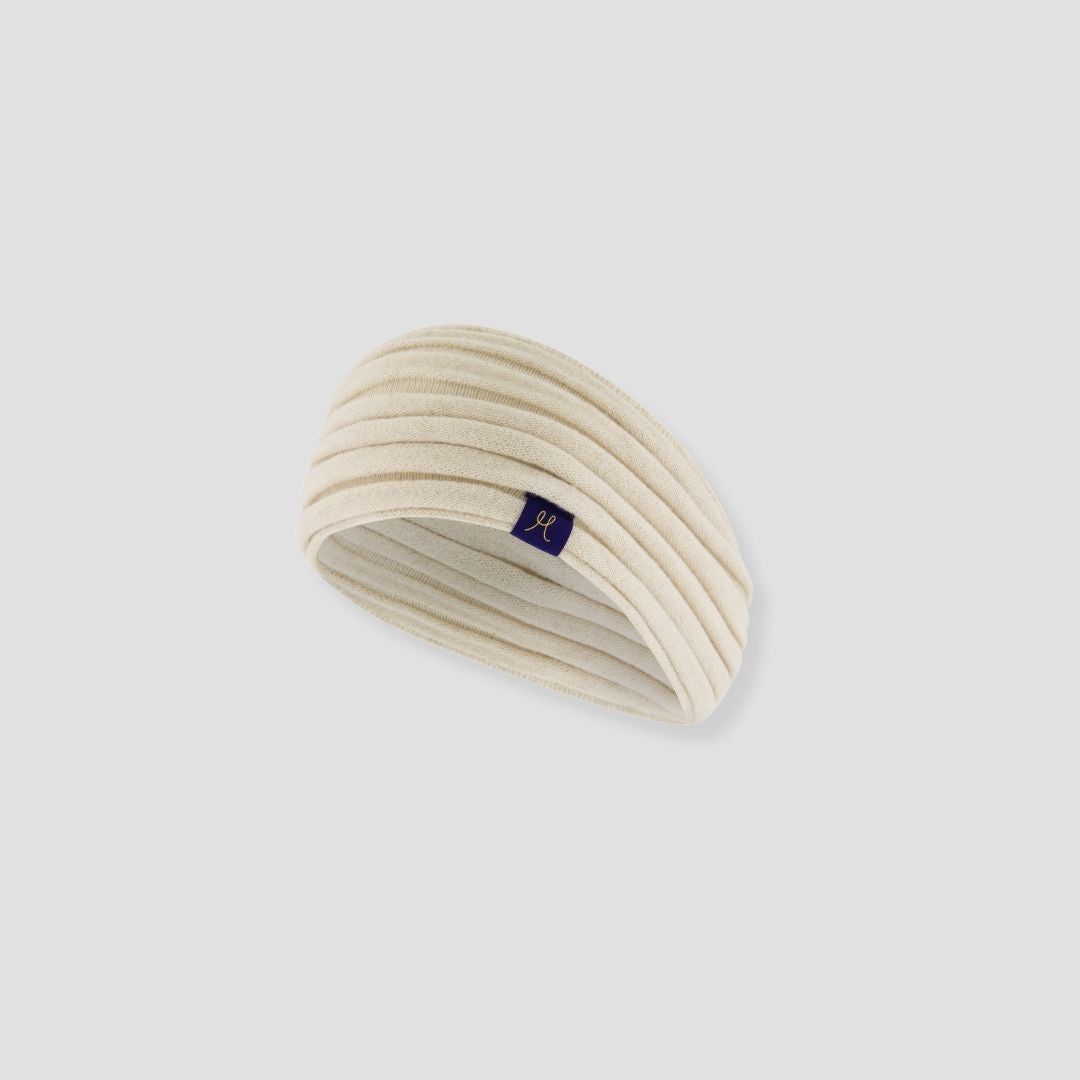 Beige headband with a small logo on a light gray background
