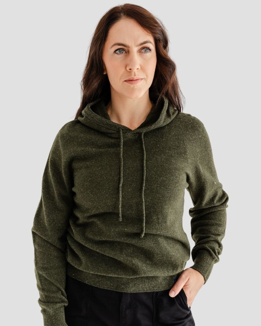 Woman wearing a green hoodie against a plain background
