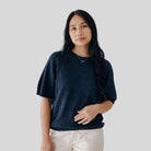 Woman wearing a dark blue shirt against a plain background