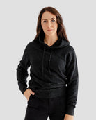 Woman wearing a dark gray hoodie on a light gray background