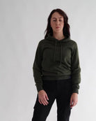 Woman wearing a green hoodie against a plain background