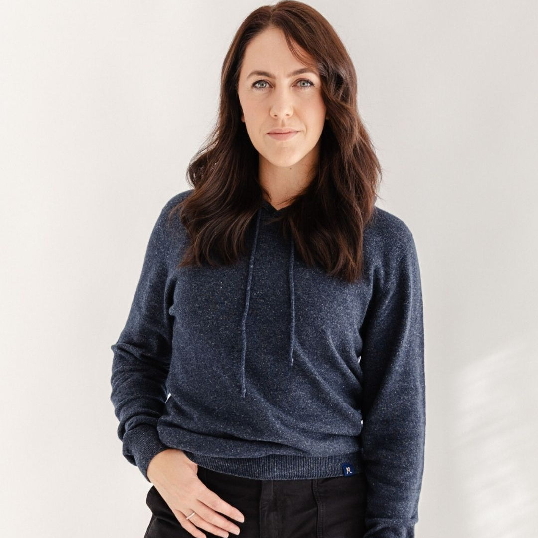 Woman wearing a blue hoodie against a white background