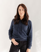 Woman wearing a blue hoodie against a white background