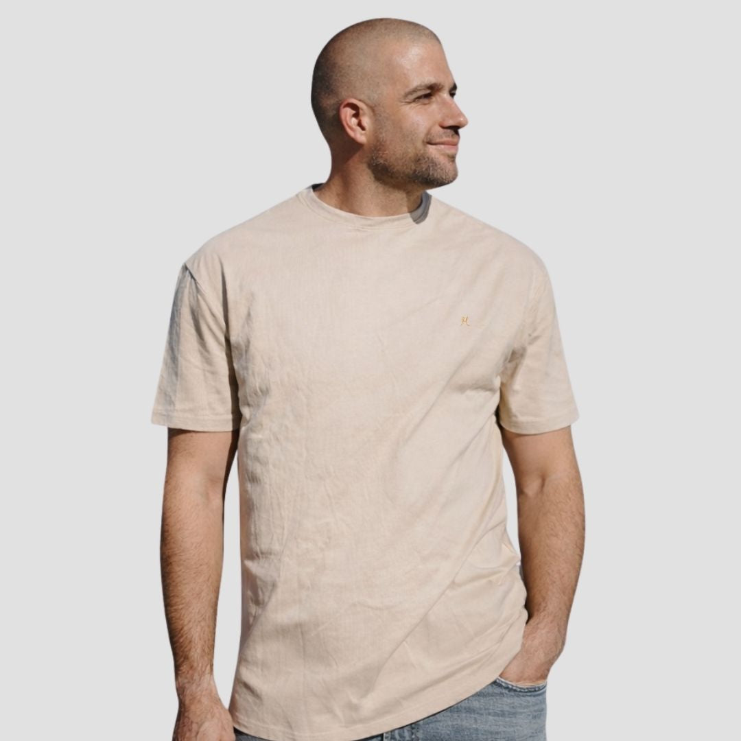 Man wearing a beige t-shirt against a plain background