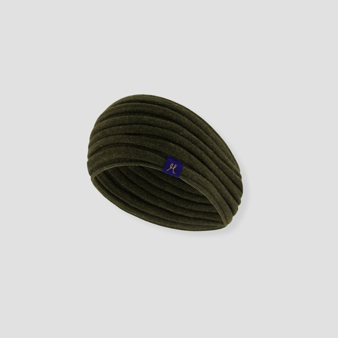 Green headband with a small logo on a light gray background