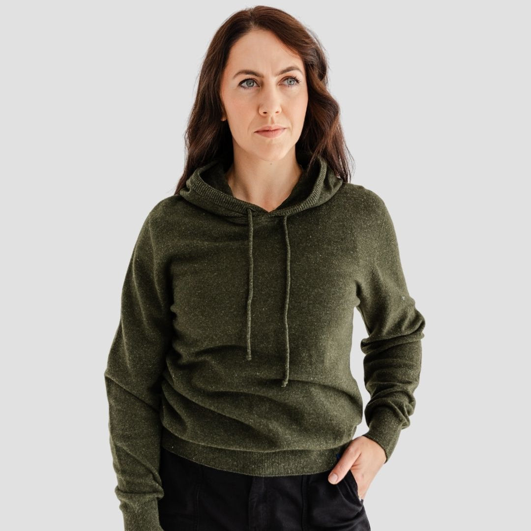 Woman wearing a green hoodie against a plain background
